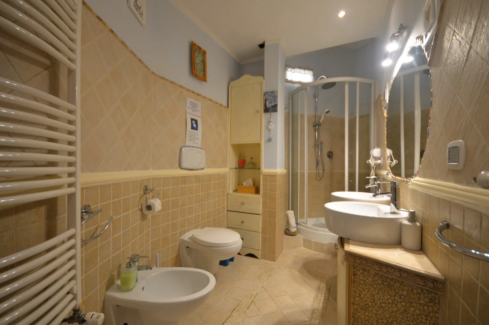 Bagno con box doccia e rivestimento in piastrelle chiare