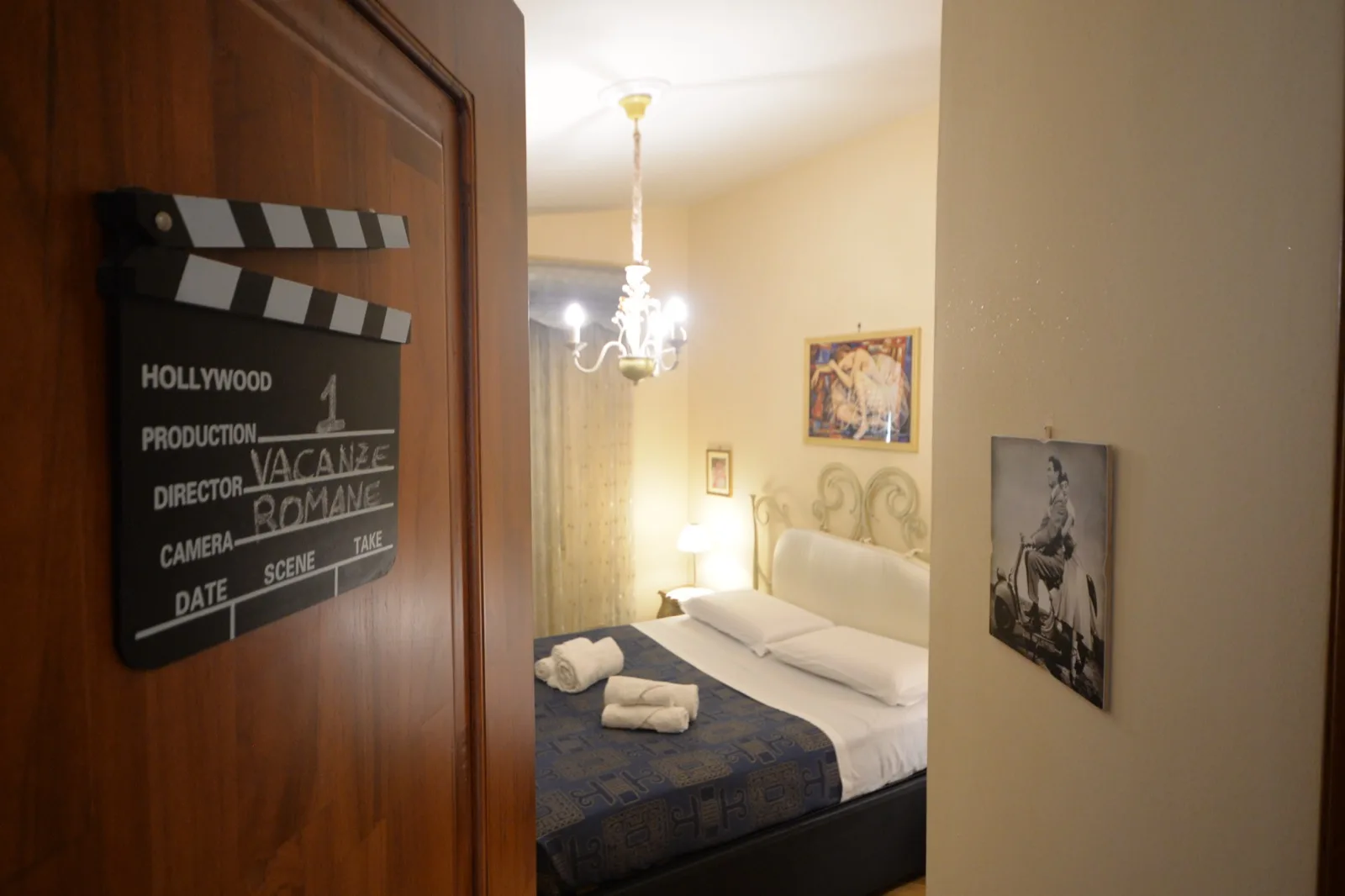 Ciak decorativo a tema cinema sull’anta dell’armadio, con la camera matrimoniale sullo sfondo