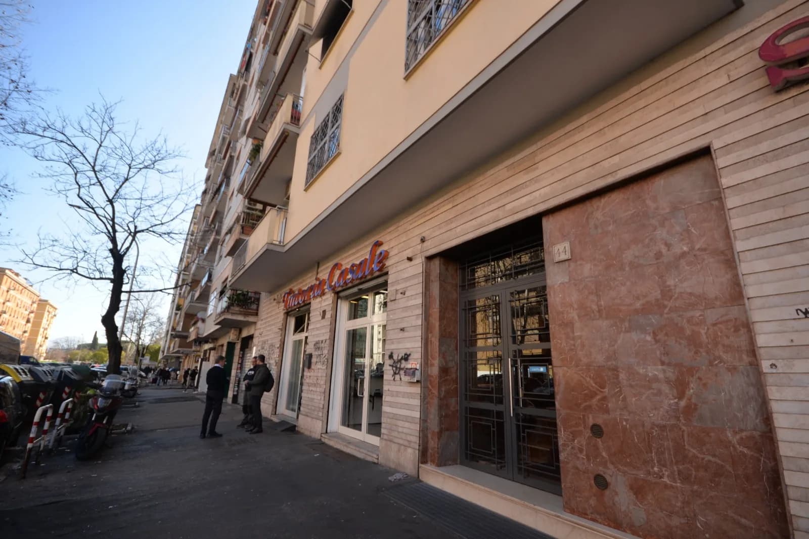Strada del quartiere Cinecittà con negozi ed edifici residenziali