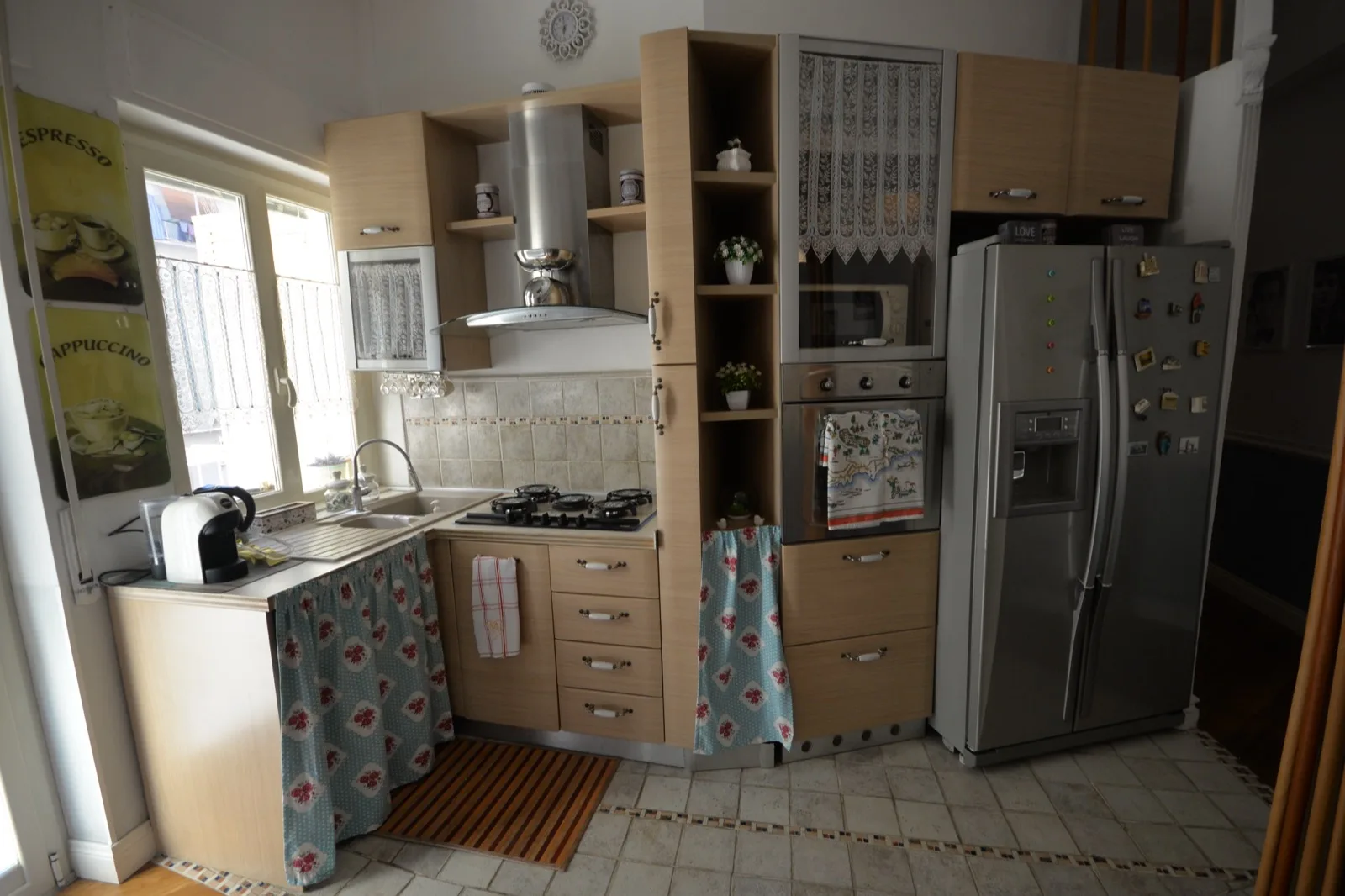 Cucina attrezzata con frigorifero, cappa e piano di lavoro